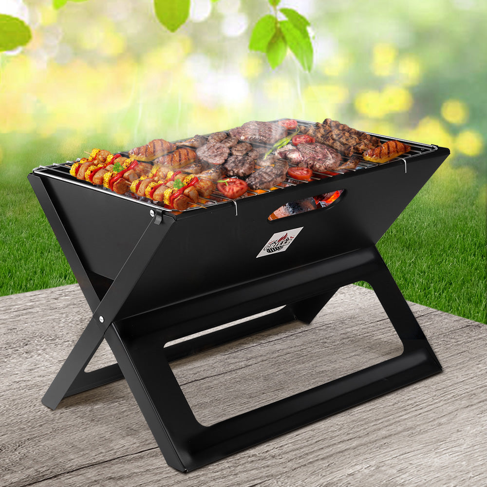 Grillz portable charcoal BBQ grill with folding X-leg design, chrome-plated grill, and steel body for compact outdoor cooking and natural wood-fired flavour.