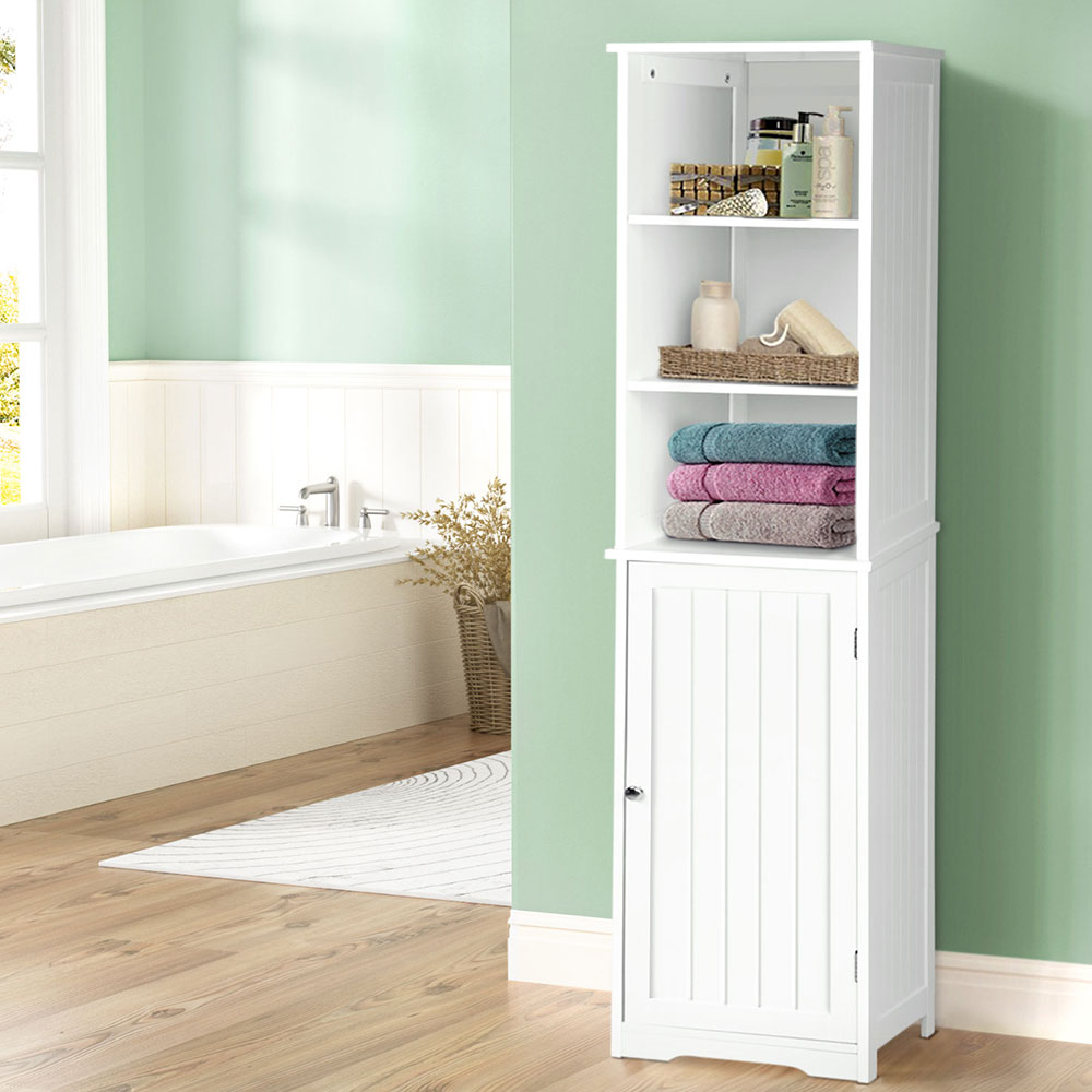 White tall narrow storage unit with shelf and door for extra bathroom storage.